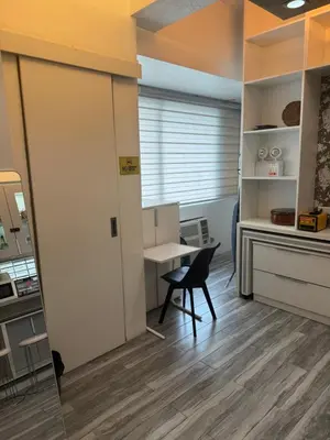 a room with a table and a chair and a desk at Greenhills shopping center 2BR condominium in Manila