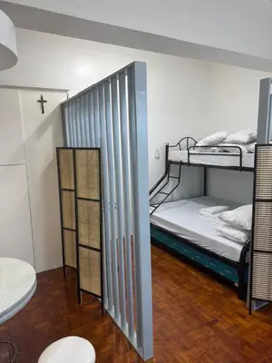 a room with two bunk beds and a cross on the wall at Greenhills shopping center studio condominium in Manila