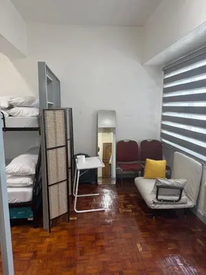 a dorm room with bunk beds and a desk at Greenhills shopping center studio condominium in Manila