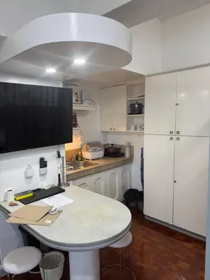 a kitchen with a table with a tv on the wall at Greenhills shopping center studio condominium in Manila
