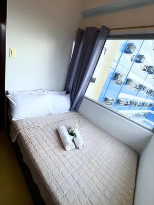 a bed in a room with a large window at 2BR Condotel Ridgewood Tower Taguig in Manila