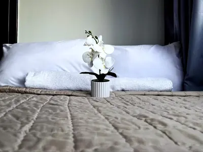 a vase of white flowers sitting on a bed at 2BR Condotel Ridgewood Tower Taguig in Manila