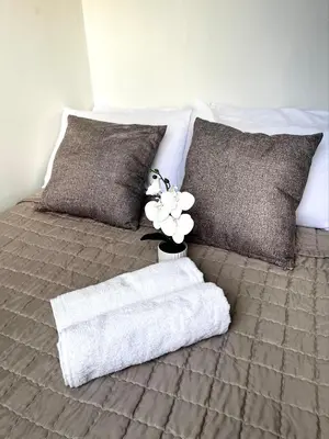 a bed with a blanket and a vase with flowers on it at 2BR Condotel Ridgewood Tower Taguig in Manila