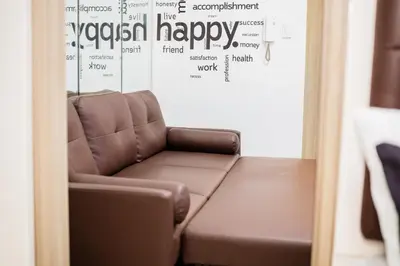 a brown leather couch in a room with a wall at Shore residences tower D Staycation near Sm moa in Manila