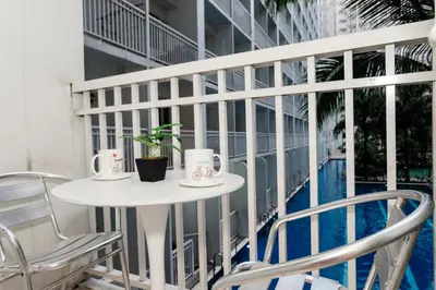 a balcony with a table and chairs and a pool at Shore residences tower D Staycation near Sm moa in Manila