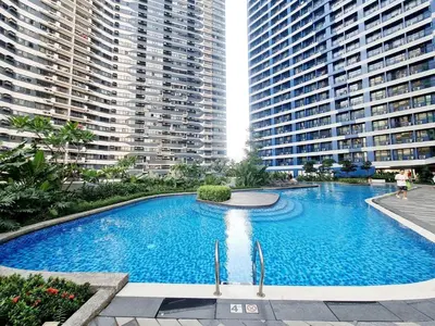 a large swimming pool in the middle of two tall buildings at The Air Residences #3724 in Manila