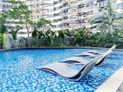 a resort swimming pool with two beds in it at The Air Residences #3724 in Manila