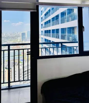 a room with a window with a view of a building at The Air Residences #3724 in Manila