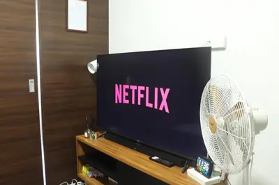 a television screen with a netflix logo on it at Cozy & Stylish Staycation and Netflix - WiFi and Pool in Manila