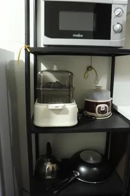 a microwave and a toaster on a black shelf at Cozy & Stylish Staycation and Netflix - WiFi and Pool in Manila