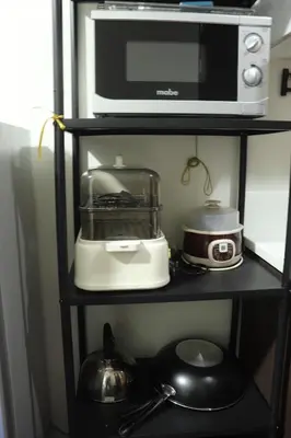 a microwave and a toaster oven on a shelf at Cozy & Stylish Staycation and Netflix - WiFi and Pool in Manila