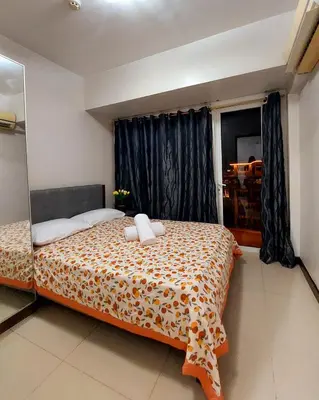 a bedroom with a large bed and a window at Solemare Parksuites in Manila