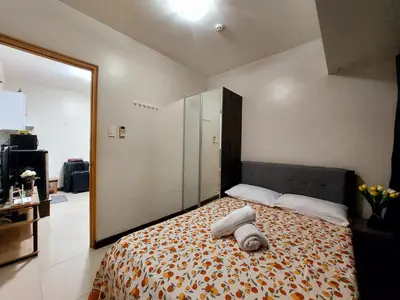 a bedroom with a bed with two towels on it at Solemare Parksuites in Manila