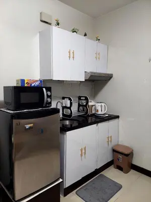 a small kitchen with a stove and a microwave at Solemare Parksuites in Manila