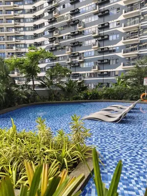 a swimming pool in front of a large building at Air Residences by Christine Suites PH Makati City in Manila