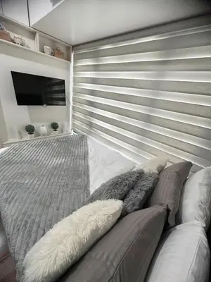 a bedroom with a couch and a flat screen tv at Air Residences by Christine Suites PH Makati City in Manila