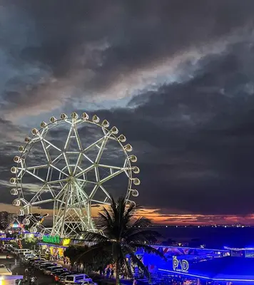 a large ferris wheel in a parking lot at night at My Staycation moa area S Residences tower1 in Manila