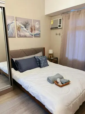 a bedroom with a bed with a tray on it at Bonifacio global city, taguig in Manila