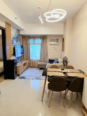 a living room with a table and chairs and a couch at Bonifacio global city, taguig in Manila