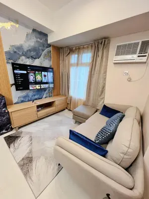 a living room with a couch and a flat screen tv at Bonifacio global city, taguig in Manila
