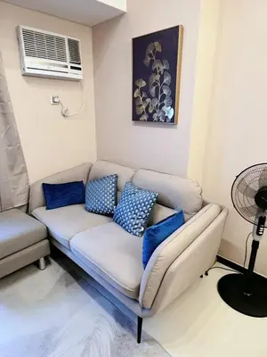 a couch in a living room with blue pillows at Bonifacio global city, taguig in Manila