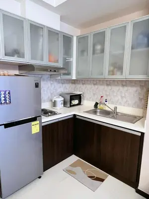 a kitchen with white cabinets and a stainless steel refrigerator at Bonifacio global city, taguig in Manila