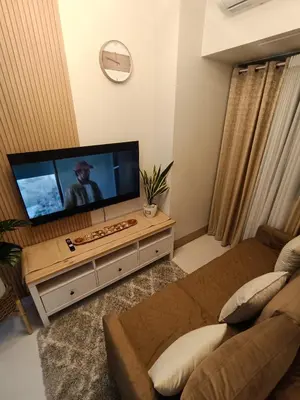 a living room with a large flat screen tv at CLMN Staycation Metro Manila in Manila