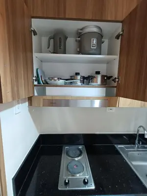 a small kitchen with a stove and a sink at CLMN Staycation Metro Manila in Manila