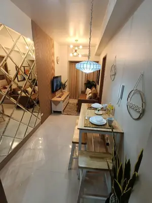 a living room with a table and a couch at CLMN Staycation Metro Manila in Manila