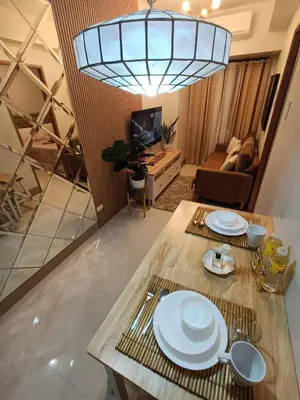 a living room with a table with plates on it at CLMN Staycation Metro Manila in Manila