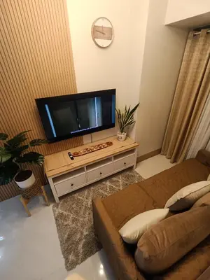 a living room with a large flat screen tv at CLMN Staycation Metro Manila in Manila