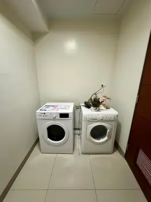 a laundry room with a washing machine and a washer at BGC One Uptown 2bedroom with balcony and 1 free parking in Manila