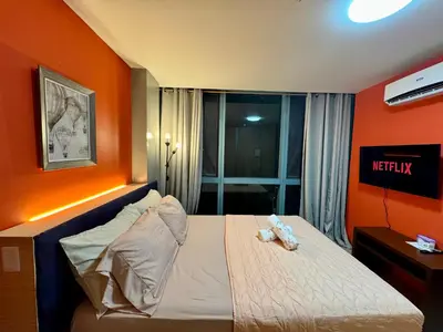 a bedroom with a bed with an orange wall at BGC One Uptown 2bedroom with balcony and 1 free parking in Manila