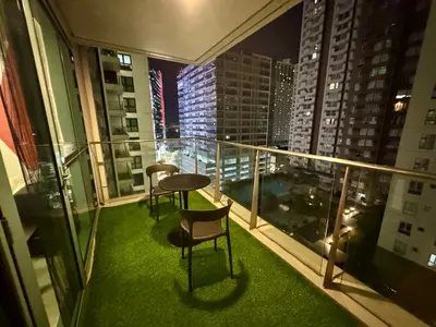 a balcony with two chairs and a table on top of a building at BGC One Uptown 2bedroom with balcony and 1 free parking in Manila
