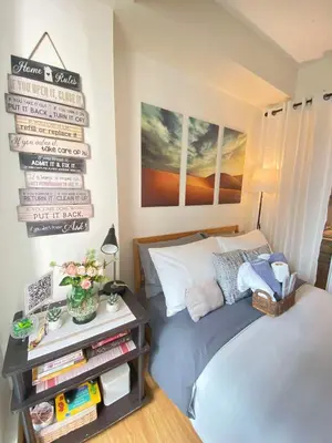 a bedroom with a bed and a sign on the wall at Bahay-Bahayan by K&A at Azure Urban Resort Residences in Manila
