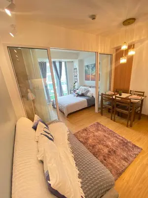 a bedroom with a bed and a table with a desk at Bahay-Bahayan by K&A at Azure Urban Resort Residences in Manila