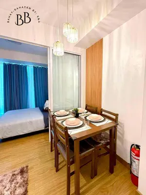 a dining room with a table and chairs and a bed at Bahay-Bahayan by K&A at Azure Urban Resort Residences in Manila