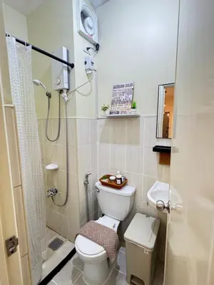 a small bathroom with a toilet and a shower at D88Staycations 105- Condo Staycation beside Enchanted Kingdom in Santa Rosa