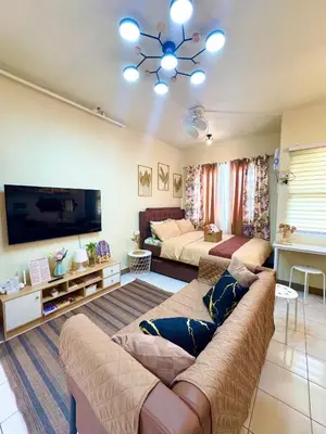 a large living room with a couch and a bed at D88Staycations 105- Condo Staycation beside Enchanted Kingdom in Santa Rosa