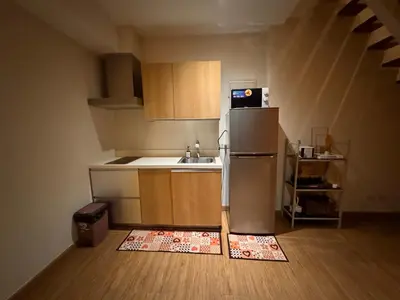 a small kitchen with a refrigerator and a sink at Gramercy Residences Spacious 1 BR Loft FREE Amenities in Manila