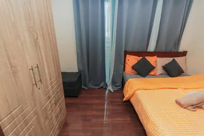 a bedroom with a bed and a door with curtains at The Quirk Inn Air residence Makati Swim Gym Park Eat Laugh 3301 in Manila