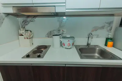 a kitchen counter with a sink and a stove at The Quirk Inn Air residence Makati Swim Gym Park Eat Laugh 3301 in Manila