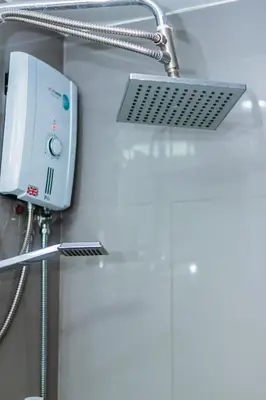 a shower head in a bathroom with a shower at Urban Hideaway Cozy Makati Giggles Swim Gym Park Laugh Eat 3352 in Manila