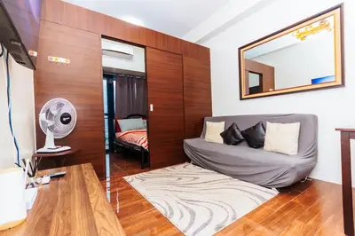 a living room with a couch and a mirror at Penthouse Perfection 5515 in Air condo Makati 300 Mbps Gym Swim Park Laugh HI speed internet in Manila
