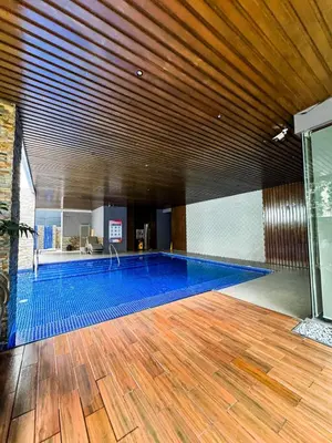 a large swimming pool in a building with a wooden ceiling at Business Studio in Salcedo Village Makati in Manila