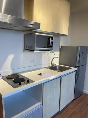 a small kitchen with a sink and a microwave at Grand Soho Makati Condo in Manila