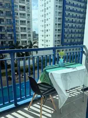 a table and a chair on a balcony at Sea Residences at Rose stayction in Manila