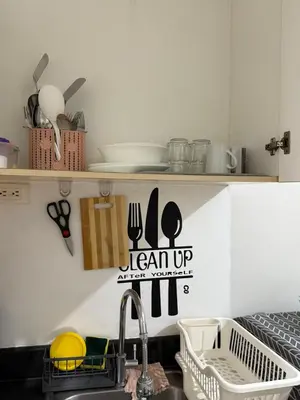 a kitchen with a sink and a sign on the wall at Sea Residences at Rose stayction in Manila