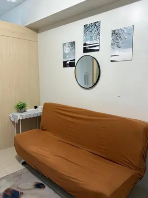 a couch in a room with a mirror on the wall at Sea Residences at Rose stayction in Manila
