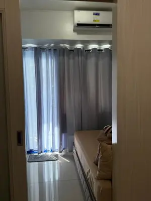 a room with a bed and a window with curtains at Sea Residences at Rose stayction in Manila